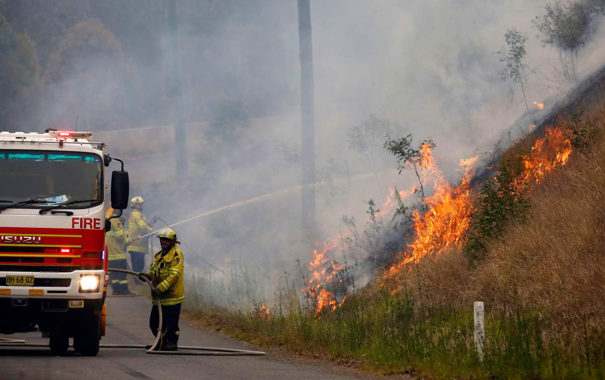 In Monday, Nov. 11, 2019, photo, firefighters work on a controlled burn in Koorainghat, New South Wales state, Australia. (Darren Pateman/AAP Images via AP)