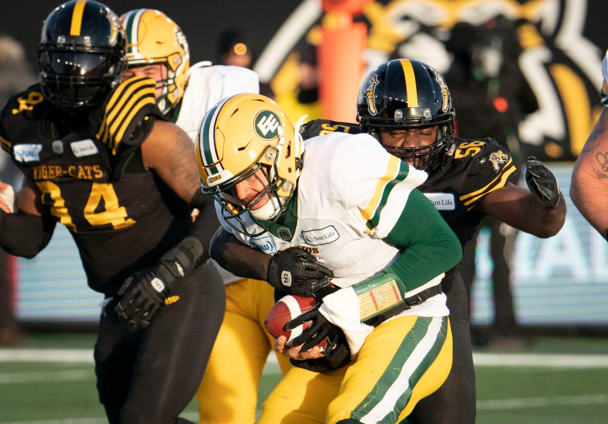 Edmonton Eskimos quarterback Trevor Harris (7) is sacked by Hamilton Tiger-Cats defensive end Ja'Gared Davis (56) during second half of CFL football East Final game action in Hamilton, Ont. on Sunday, Nov. 17, 2019. 