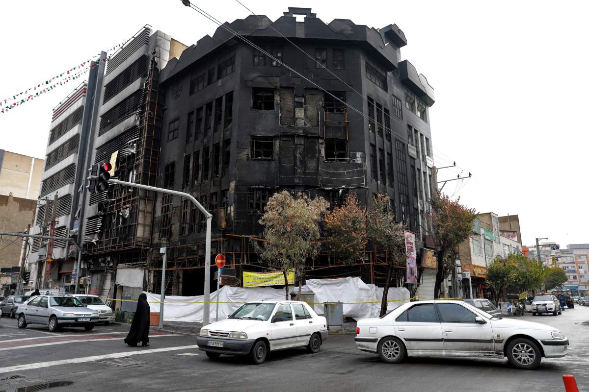 In this Nov. 20, 2019 photo, traffic passes a building that was set ablaze during recent protests over government-set gasoline prices rises, in Tehran, Iran.