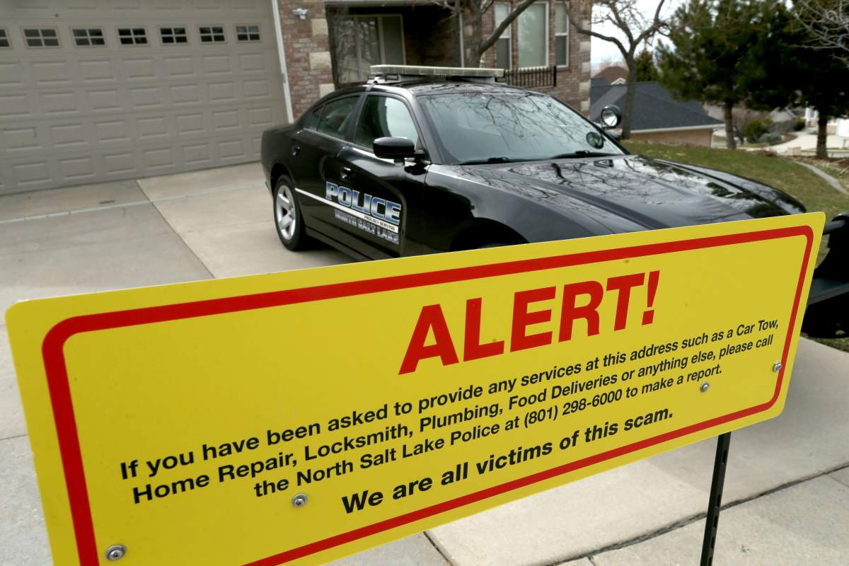 This March 21, 2019 photo shows a warning sign and a police officer’s vehicle at Walt Gilmore’s home in North Salt Lake, Utah.