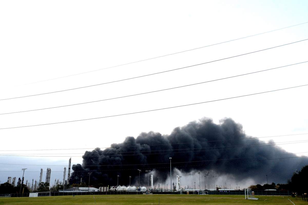 Thick smoke fills the sky above the TPC Group Port Neches Operations as emergency response crews try to contain the fire that continued to burn throughout the morning following an overnight explosion on Wednesday, Nov. 27, 2019, in Port Neches, Texas. (Kim Brent/The Beaumont Enterprise via AP)