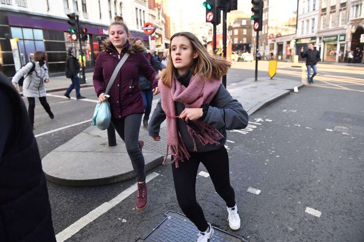 People are evacuated from London Bridge in central London following a police incident, Friday, Nov. 29, 2019. (Dominic Lipinski/PA via AP)