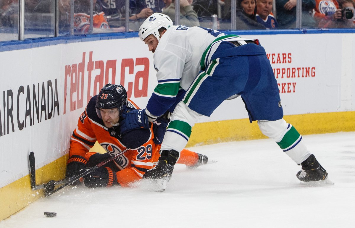 Vancouver Canucks' Jay Beagle (83) checks Edmonton Oilers' Leon Draisaitl (29) during second period NHL action in Edmonton, Saturday, Nov. 30, 2019. THE CANADIAN PRESS/Jason Franson.