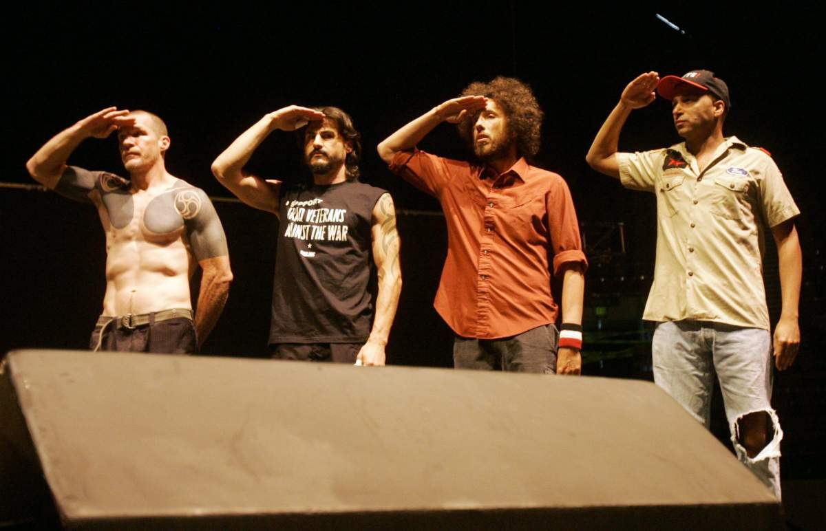 Members of the band Rage Against the Machine salute veterans during an anti-war concert at the Democratic National Convention in Denver, Wednesday, Aug. 27, 2008. Seen from left to right, Tom Morello, Brad Wilk, Zack de la Rocha and Tim Commerford.
