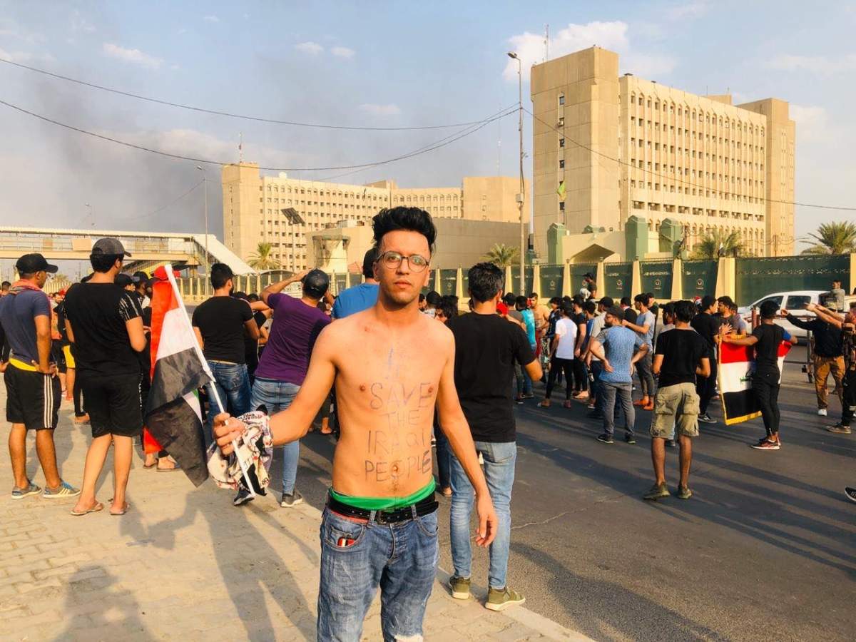 “Save the Iraqi people” is written on a protester’s body.