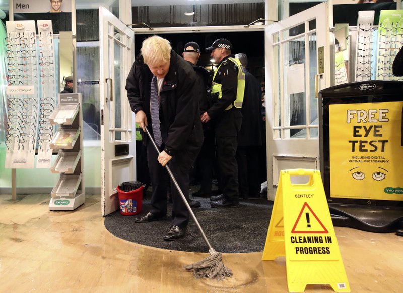 Britain's Prime Minister Boris Johnson visits an optician shop after flooding, in Matlock, north England, Friday Nov. 8, 2019. A woman died after being swept away by surging waters as torrential rain drenched parts of north and central England, swelling rivers, forcing evacuations and disrupting travel for a second day Friday. 