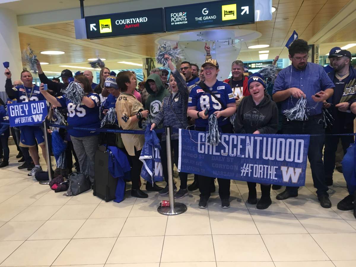 Fans wait to greet the Winnipeg Blue Bombers at the Winnipeg airport Monday.