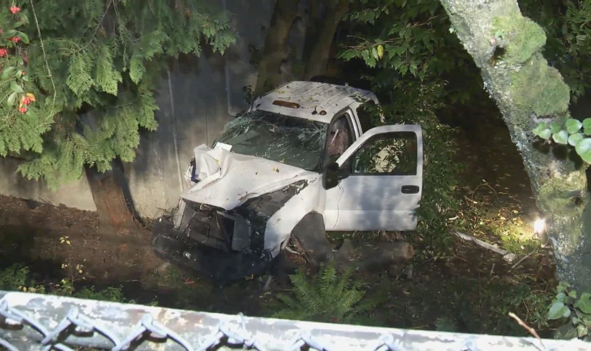 A vehicle sits damaged in the ground of a Burnaby apartment building on Nov. 22, 2019.