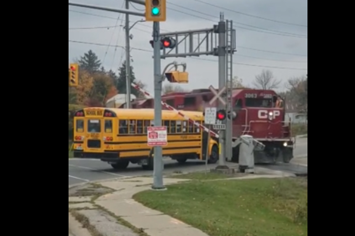 The school bus was caught underneath the railway crossing arm.
