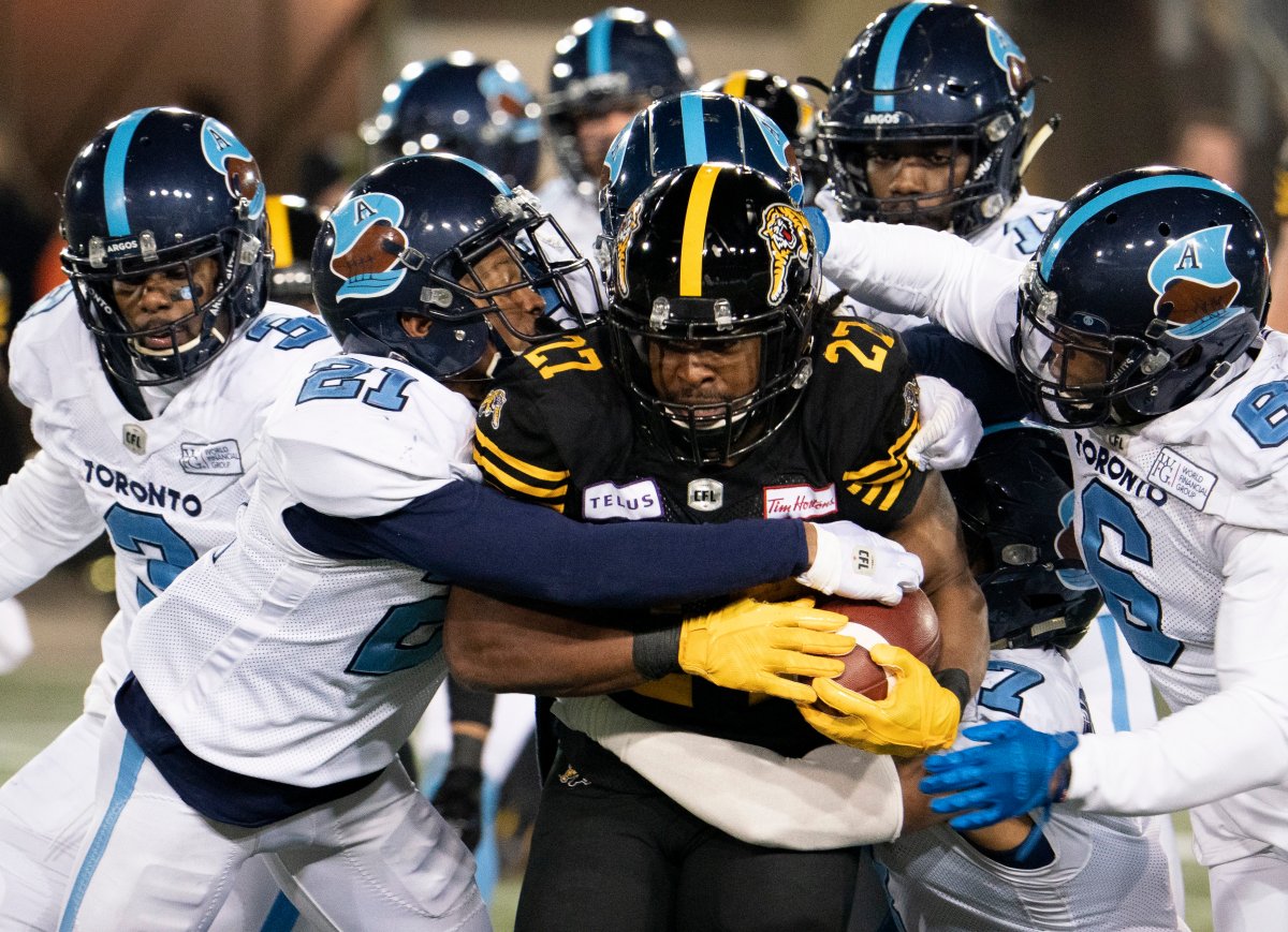 Hamilton Tiger Cats running back Cameron Marshall (27) is swarmed by Toronto Argonauts during first half CFL football action in Hamilton, Ont., Saturday, Nov. 2, 2019.