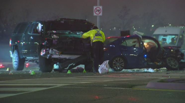 An officer looks at two damaged vehicles in Mississauga.