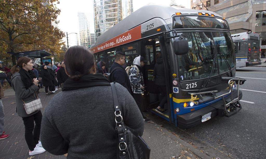 Passengers board a bus in downtown Vancouver, Friday, November, 1, 2019. 