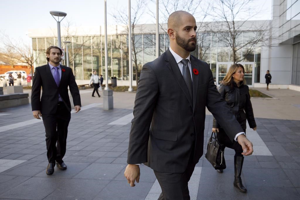 Michael Theriault, centre, and Christian Theriault, left, arrive at the Durham Region Courthouse in Oshawa, Ont., ahead of Dafonte MIller's testimony, on Wednesday, Nov. 6, 2019. A Toronto police officer has taken the stand at his aggravated assault trial, acknowledging he caused the victim's severe eye injury. THE CANADIAN PRESS/Cole Burston.