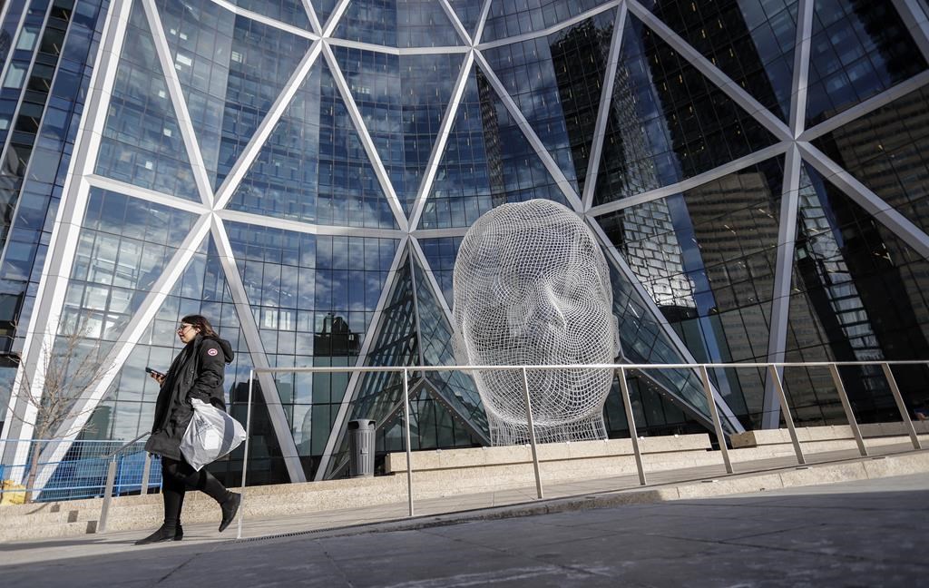 A pedestrian walks past The Bow building where Encana Corp. has it's company headquarters in Calgary on October 31, 2019. The brand Encana Corp. immediately brings to mind two things: energy and Canada. But Ovintiv, the name with which the oil and gas producer plans to re-christen itself once it moves its home base to the United States next year, offers no hint of what it does or where it's from. Branding experts say that's likely the point. THE CANADIAN PRESS/Jeff McIntosh.