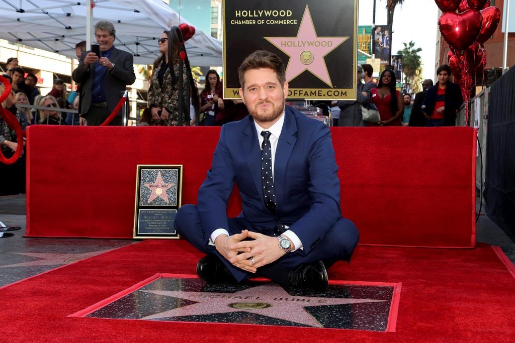 Michael Buble sits atop his star at a ceremony honouring him with a star on the Hollywood Walk of Fame in Los Angeles, Friday, Nov. 16, 2018.