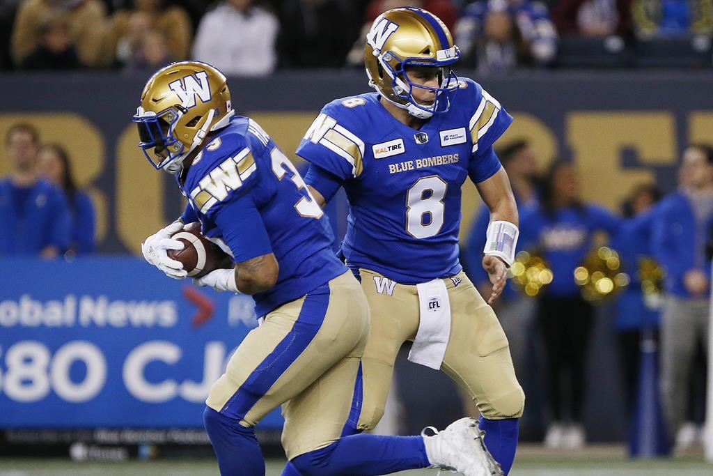Winnipeg Blue Bombers quarterback Zach Collaros (8) hands off to Andrew Harris (33) during the first half of CFL action against the Calgary Stampeders in Winnipeg Friday, October 25, 2019. Quarterback Zach Collaros worked with Winnipeg's first-team offence Wednesday as the Blue Bombers prepared for Sunday's West Division semifinal at Calgary.THE CANADIAN PRESS/John Woods.