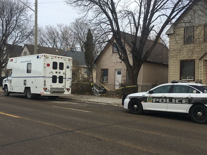 A Winnipeg Police Service cruiser and identification van at the scene of a fatal shooting.