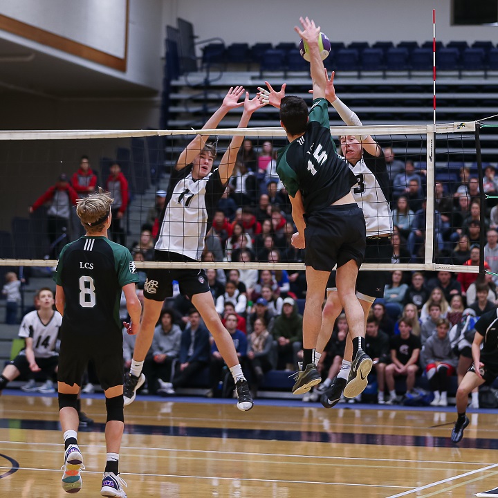 A spike by Langley Christian powers past a pair of George Elliot defenders during B.C. high school volleyball boys 2A semifinal action in Langley on Friday.