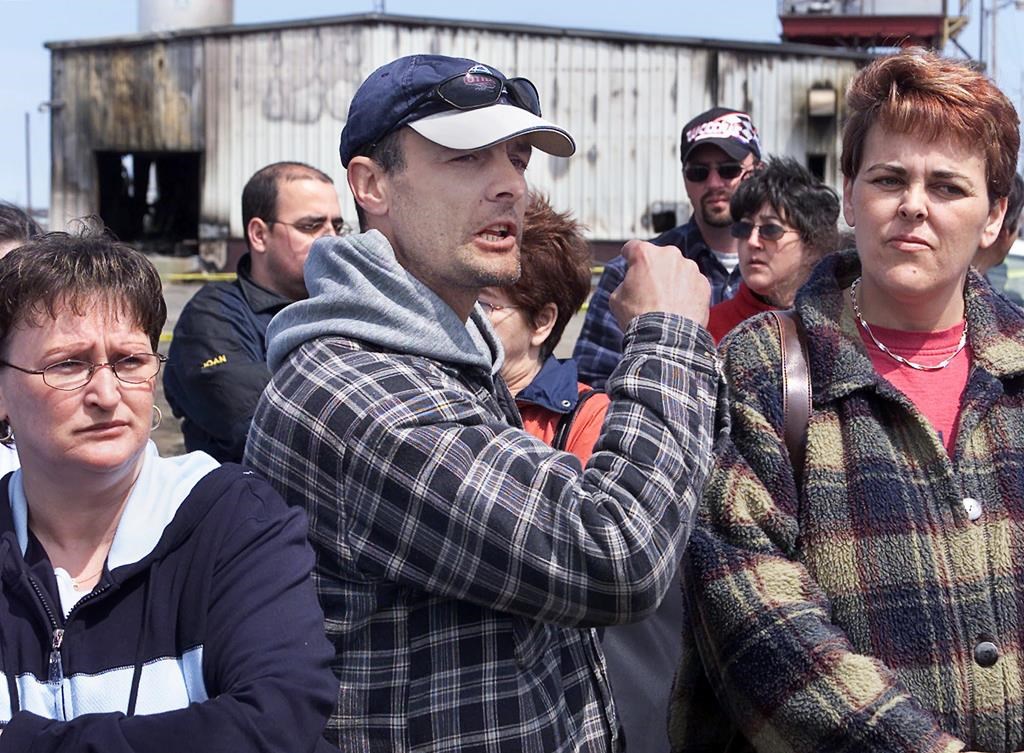 Angry out-of-work fish plant workers express their frustration outside their burned-out plant in Shippagan, N.B on Tuesday, May 6, 2003. Several boats and buildings were destroyed by fire on the weekend as fishermen protested cuts to the crab quota. A Moncton judge has dismissed a $40 million lawsuit against the RCMP and ordered the receivers of a Shippagan fish plant — destroyed in a riot in 2003 — to pay $210,000 in legal costs.