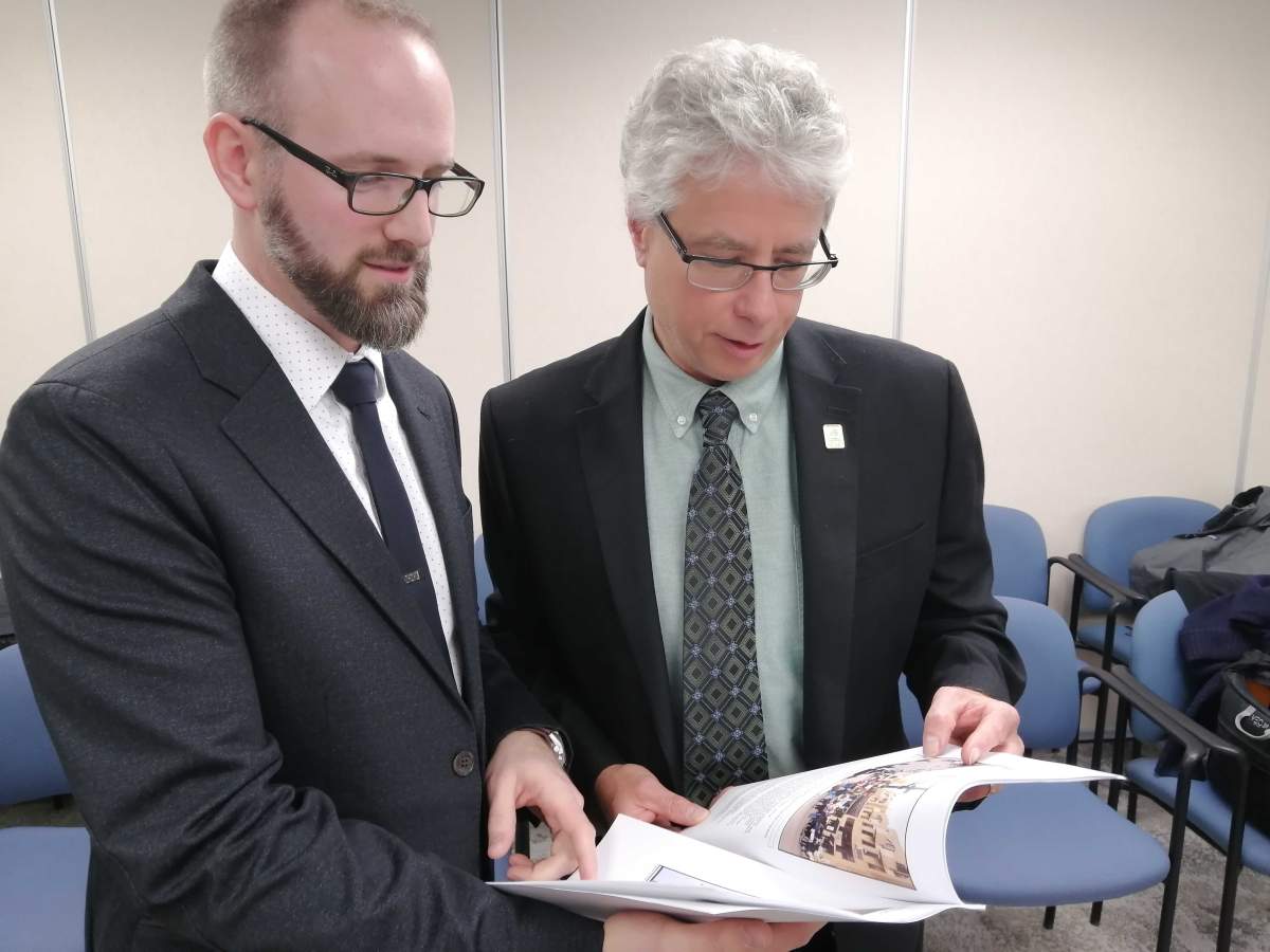 Sustainability and resiliency manager Mike Fabro (left) and environment, fleet, and solid waste director Jay Stanford (right) flip through a climate change emergency update report on Wed., Nov. 20, 2019.