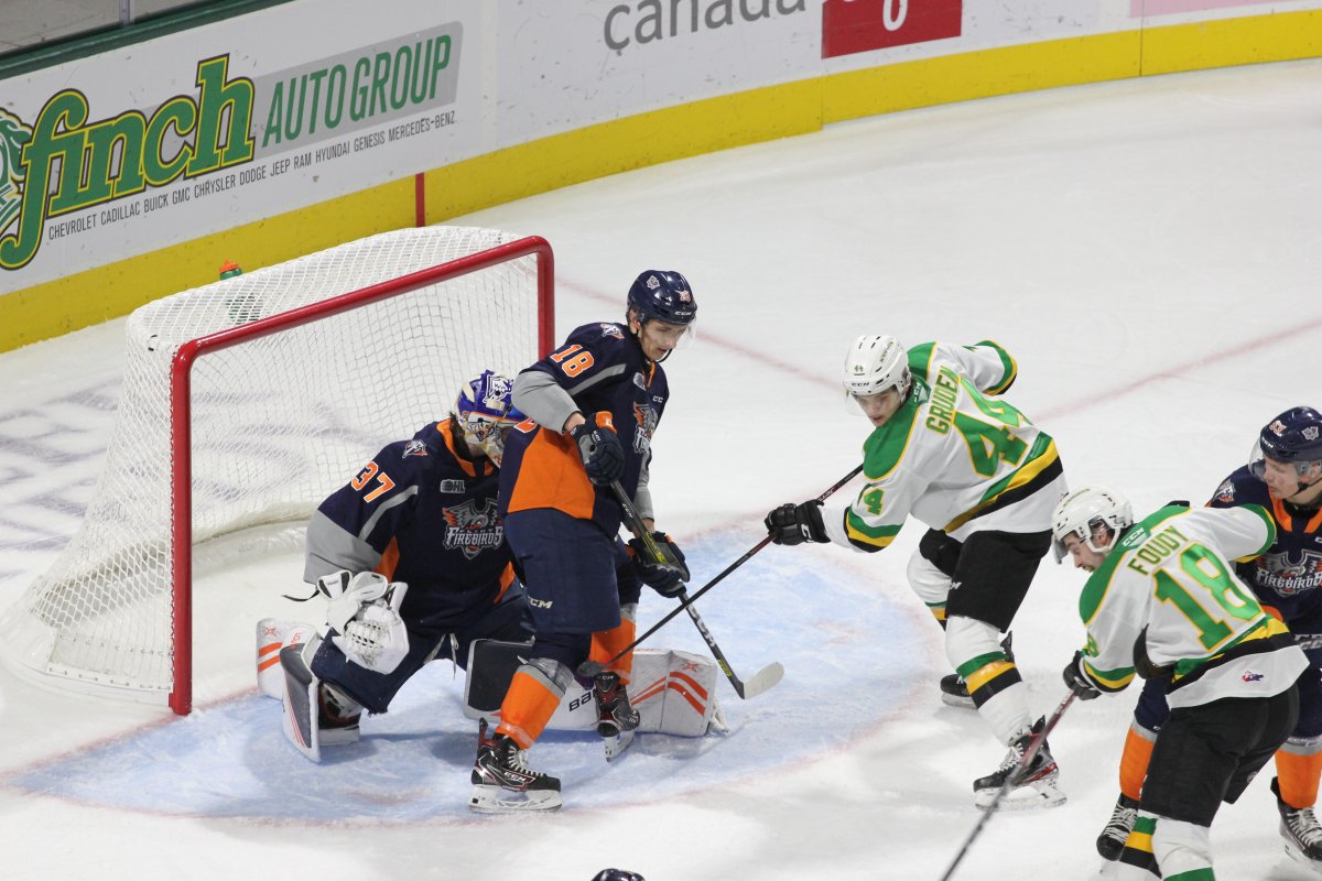 London, Ont. - Liam Foudy and Jonathan Gruden of the London Knights try to put a puck past Luke Cavallin of the Flint Firebirds in a game that Flint won 6-1 at Budweiser Gardens on November 15, 2019.