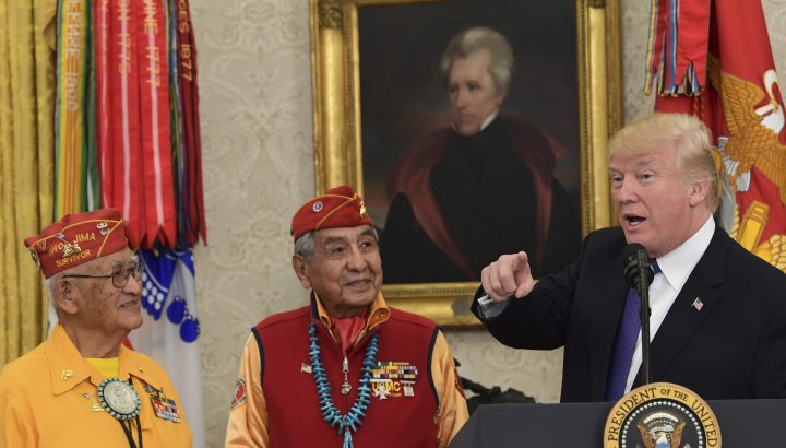 In this photo from Monday, Nov. 27, 2017, President Donald Trump, right, speaks during a meeting with Navajo Code Talkers including Thomas Begay, left, and Peter MacDonald, center, in the Oval Office of the White House in Washington. 