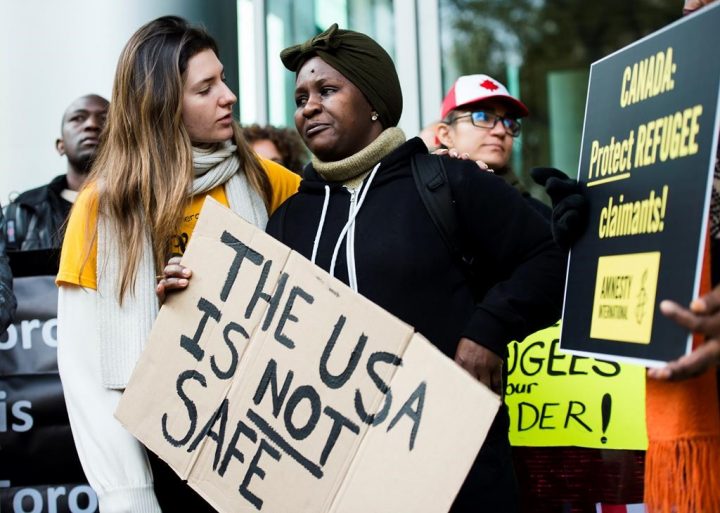 Kikome Afisa, right, is comforted as she along with others protest outside the Federal Court of Canada building for a hearing of the designation of the U.S. as a safe third country for refugees in Toronto on Monday, Nov. 4, 2019.