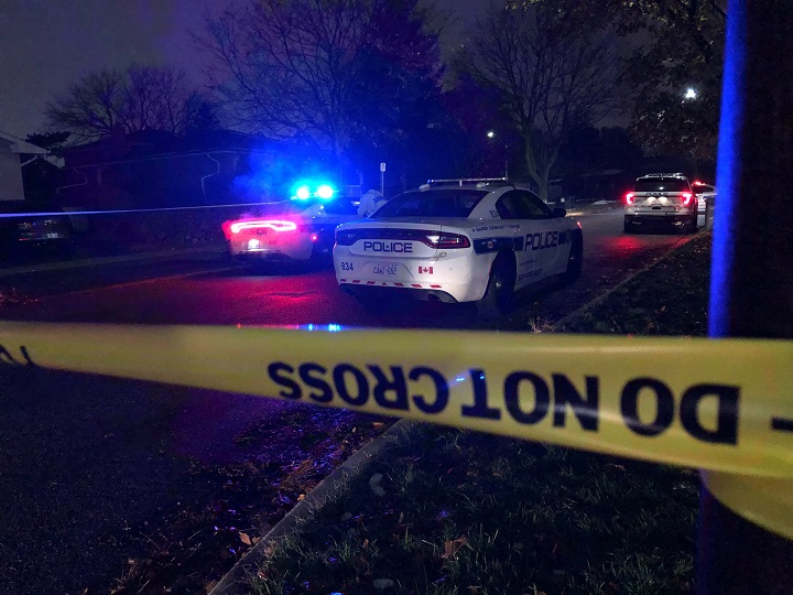 Police cruisers on scene at a crime scene at night.