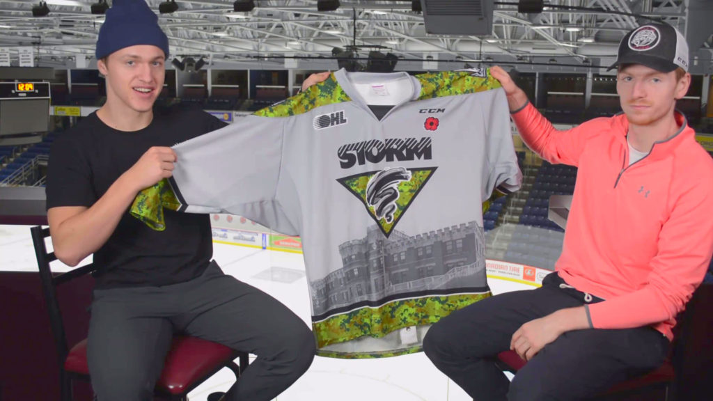 Guelph Storm players Clark Hiebert and Josh Wainman show off the commemorative jerseys that will be worn by the team on Saturday night. 