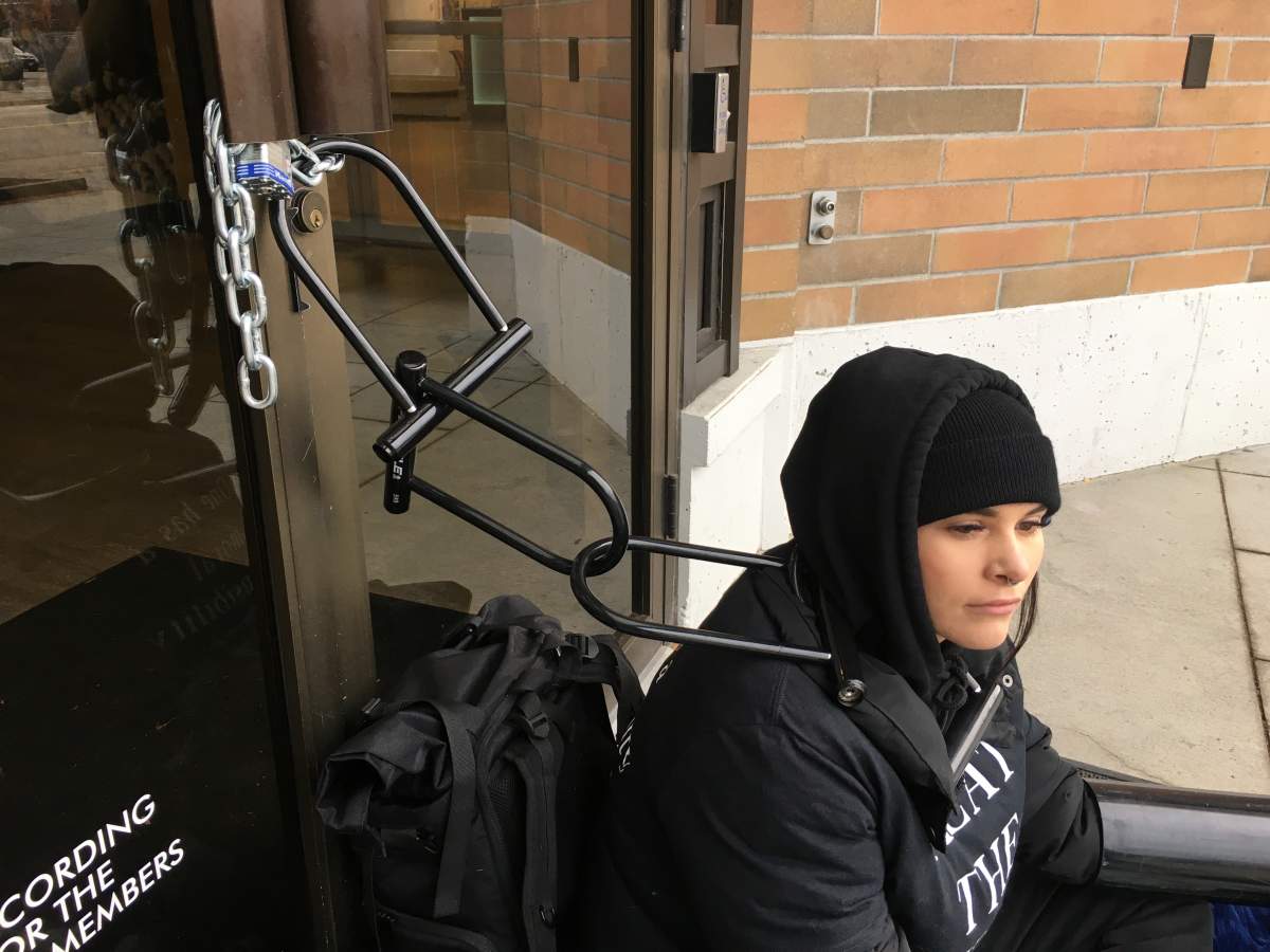 A protester chains herself to the Interior Savings building in Kelowna in an effort to protest against Rib Fest.