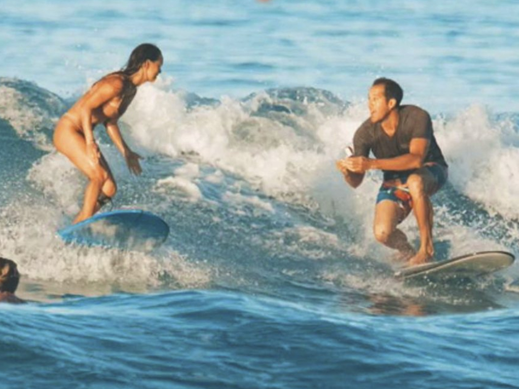 A Hawaiian couple got engaged while surfing a wave.