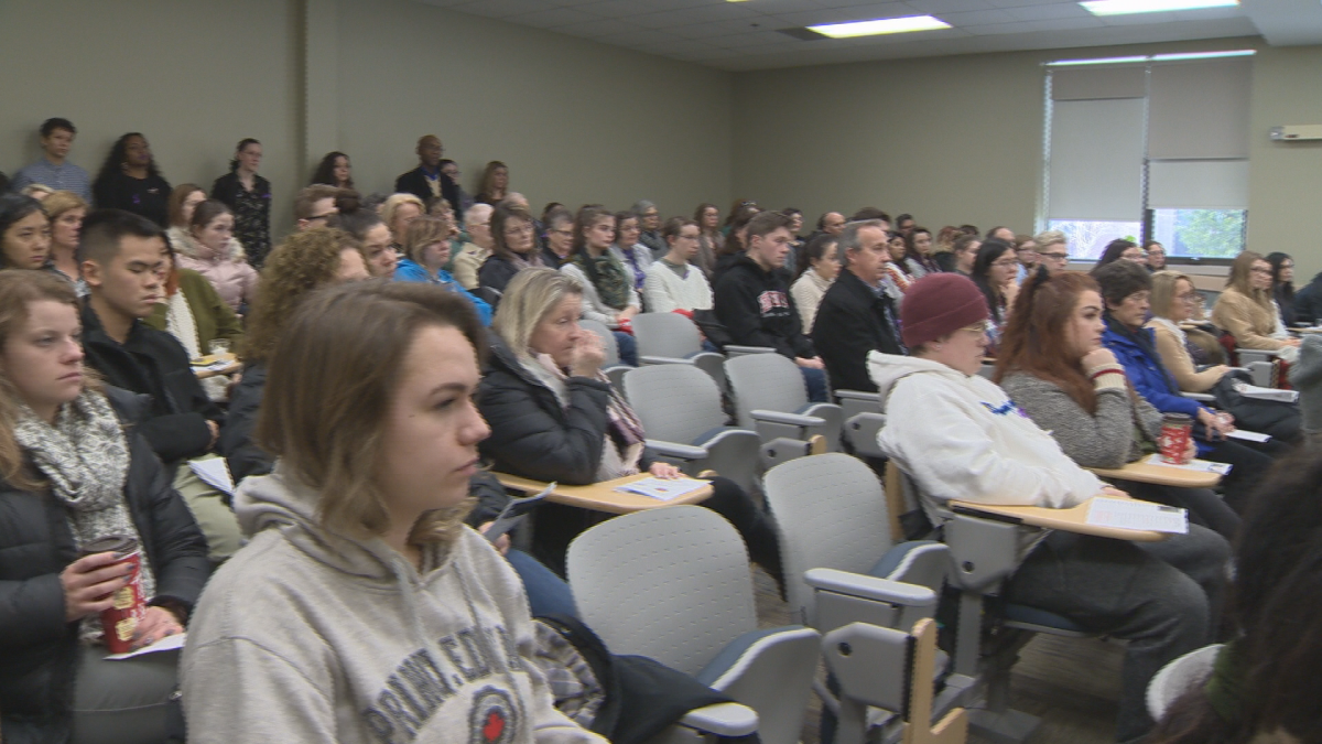 An audience inside UNBSJ reflects on the Montreal Massacre.