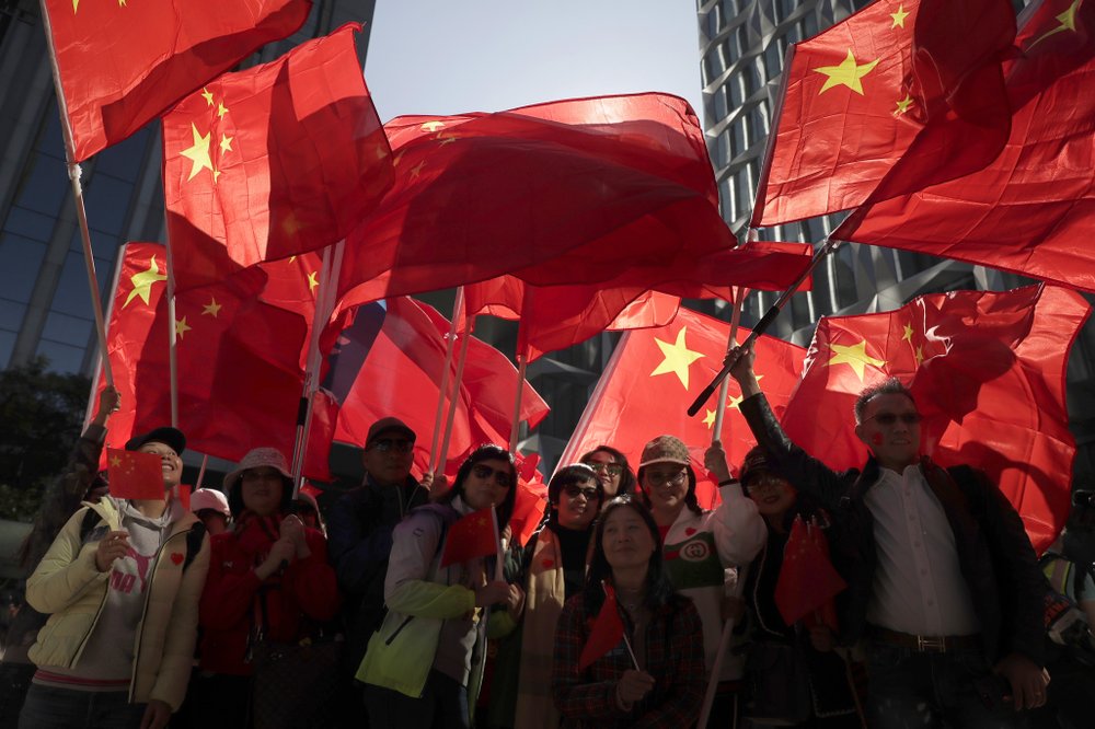 Pro-Beijing supporters wave the Chinese national flags during a rally in Hong Kong on Saturday, Dec. 7, 2019. Six months of unrest have tipped Hong Kong's already weak economy into recession.