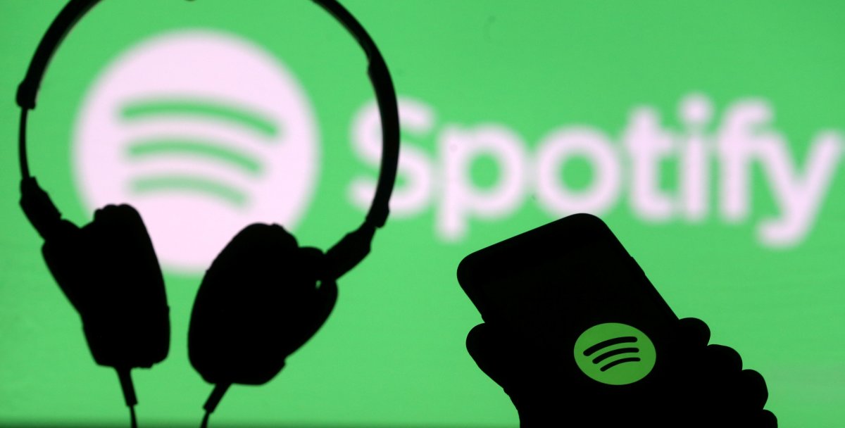 A smartphone and a headset are seen in front of a screen projection of Spotify logo, in this picture illustration taken April 1, 2018. 