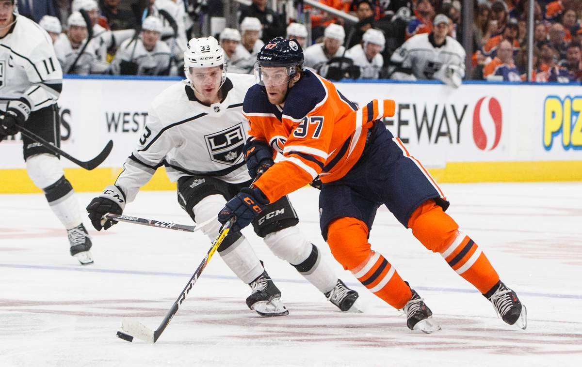 Los Angeles Kings' Tobias Bjornfot (33) chases Edmonton Oilers' Connor McDavid (97) during second period NHL action in Edmonton, Saturday, Oct. 5, 2019. THE CANADIAN PRESS/Jason Franson.