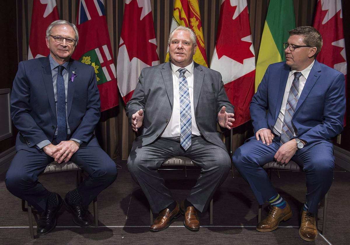 Ontario Premier Doug Ford, centre, speaks to reporters as Saskatchewan Premier Scott Moe, right, and New Brunswick Premier Blaine Higgs look on during a meeting of Canada’s premiers in Montreal, Dec. 6, 2018.