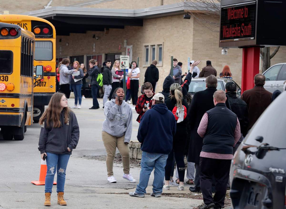 Waukesha South High School students find their waiting parents and friends and hug after they leave the building following shots fired inside the school, Dec. 2, 2019.