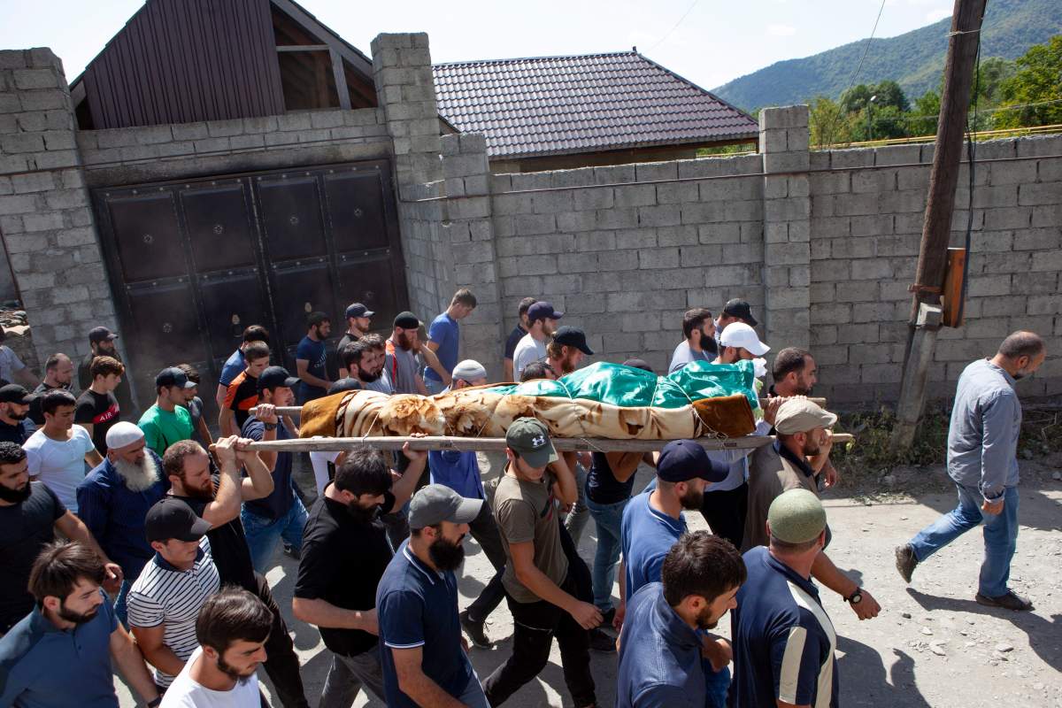 In this Aug. 29, 2019 photo people carry the body of the victim who has been identified as Zelimkhan Khangoshvili, a Georgian Muslim during the funeral in Duisi village, the Pankisi Gorge valley, in Georgia.