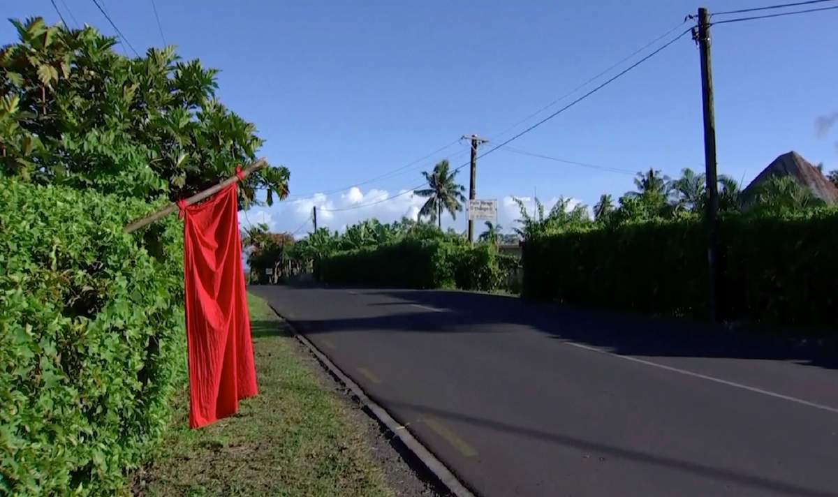 In this image from a video, a red flags hangs outside homes of residents who have not been vaccinated in Apia, Samoa, Thursday, Dec. 5, 2019.  (TVNZ via AP)