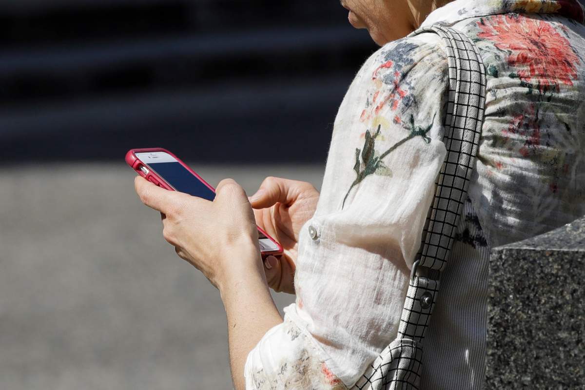 FILE - In this April 8, 2019, file photo, a woman browses her smartphone in Philadelphia.