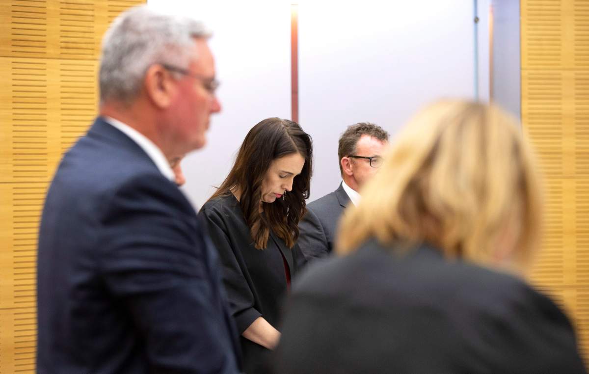 New Zealand Prime Minister Jacinda Ardern observes a moment of silence with her cabinet colleagues at the moment that a volcano erupted a week earlier, killing 18 people and leaving others with severe burns, in Wellington, New Zealand, Monday, Dec. 16, 2019.