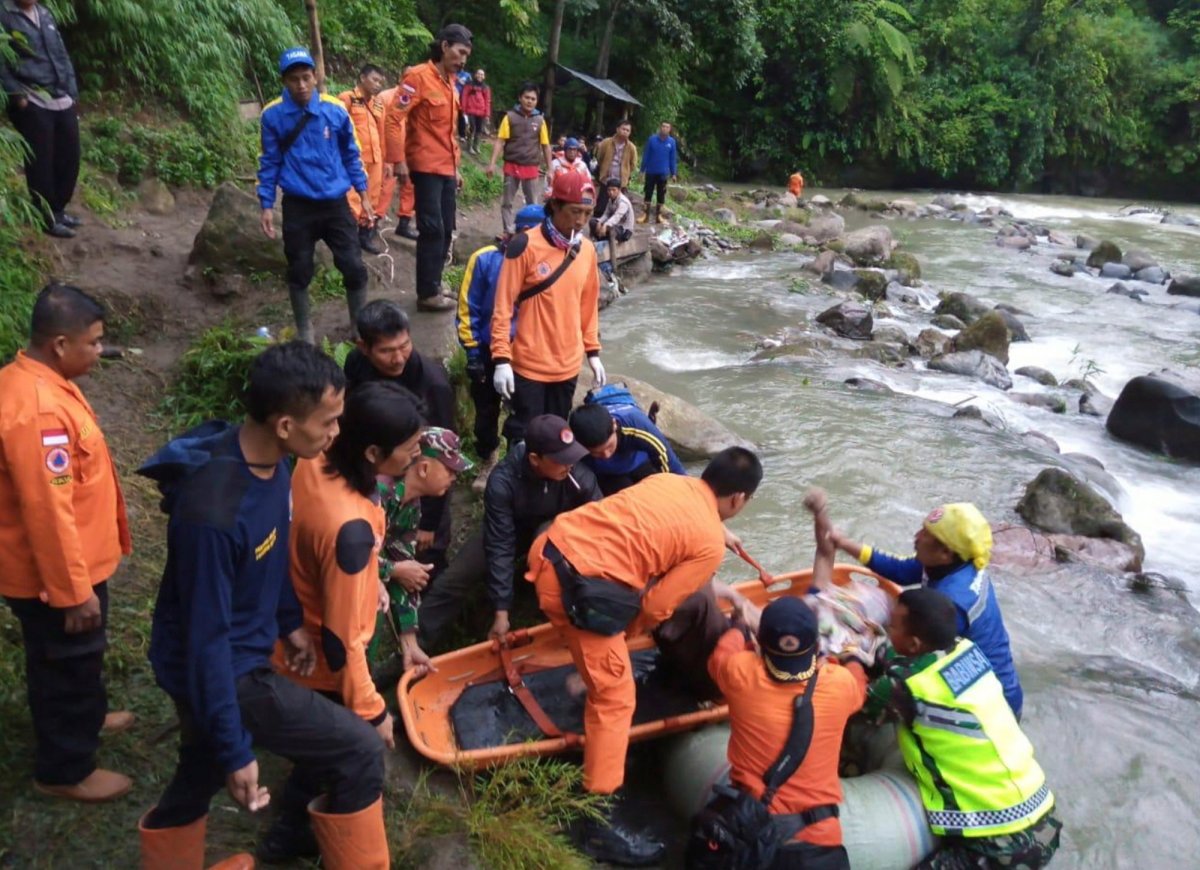 In this photo released by the National Search And Rescue Agency (BASARNAS), rescuers remove the body of a victim of a bus accident in Pagaralam, Indonesia, Tuesday, Dec. 24, 2019. A number of people were killed when the passenger bus plunged into the ravine on Sumatra island after its brakes apparently malfunctioned, police said Tuesday. 