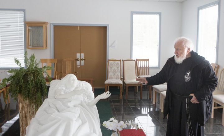 Father Claudio Piccinini, a Catholic priest and founder of “Teopoli, the City of God,” a religious place of worship, in Gravenhurst, Ont., stands with a white Carrara marble monument of Sister Carmelina lying in her hospital bed, on Friday, December 13, 2019.