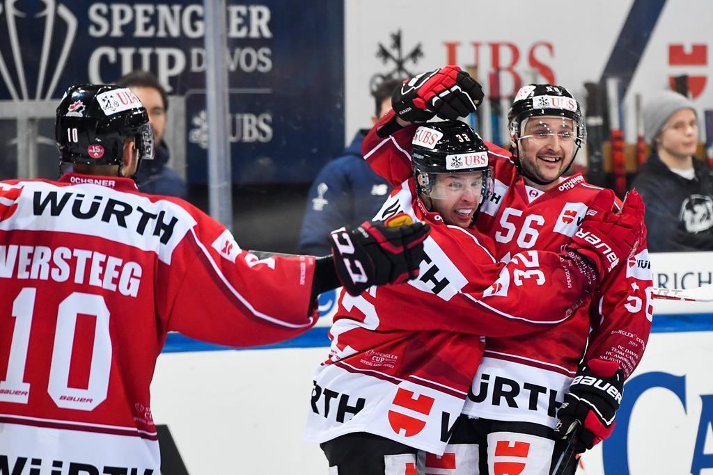 Team Canada's Kevin Clark, center, celebrates after scoring his side opening goal with Team Canada's Maxim Noreau, right, during the game between Team Canada and TPS Turku, at the 93th Spengler Cup ice hockey tournament in Davos, Switzerland, Monday, Dec. 30, 2019.