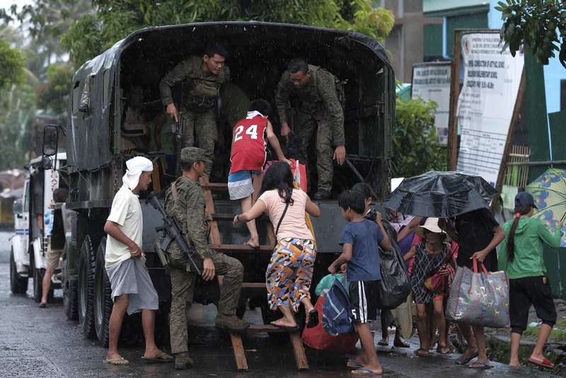 Residents ride a military truck as they evacuate to safer grounds in preparation for the coming of Typhoon Kammuri in Legazpi, Albay province, southeast of Manila, Philippines on Monday Dec. 2, 2109. The Philippines' main island, including the national capital, Manila, is under a tropical cyclone warning for a typhoon forecast to hit Monday night into Tuesday. 