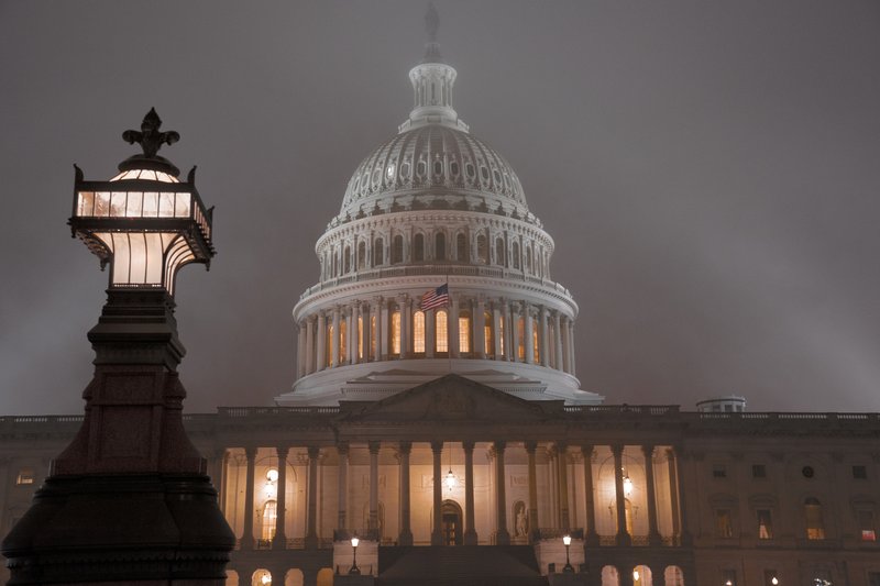 The U.S. Capitol in Washington is shrouded in mist, Friday night, Dec. 13, 2019. This coming week’s virtually certain House impeachment of President Donald Trump will underscore how Democrats and Republicans have morphed into fiercely divided camps since lawmakers impeached President Bill Clinton.