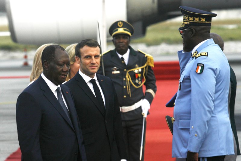 French President Emmanuel Macron is welcomed by President Alassane Ouattara upon arrival in Abidjan, Ivory Coast, Friday Dec. 20, 2019. Macron is in Ivory Coast for a three-day official visit. 