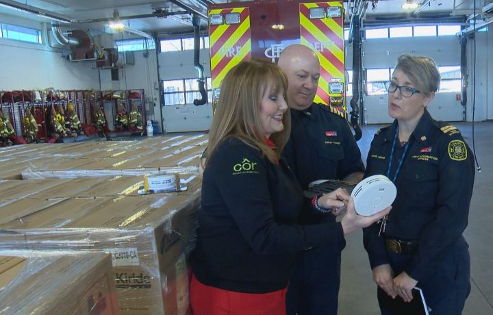 Sharon Cooksey (left), a fire safety expert with Kidde Canada,​ Deputy Calgary Fire Department Chief Ken Uzeloc (middle), and CFD public information officer Carol Henke discuss Kidde's donation of 3,000 smoke alarms to the CFD on Monday, Dec. 16, 2019.