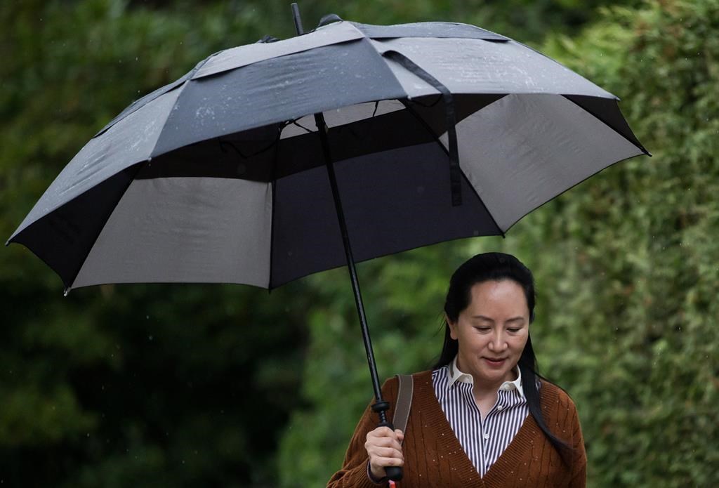 Huawei chief financial officer Meng Wanzhou, who is out on bail and remains under partial house arrest after she was detained last year at the behest of American authorities, carries an umbrella to shield herself from rain as she leaves her home to attend a court hearing, in Vancouver on Thursday October 3, 2019.