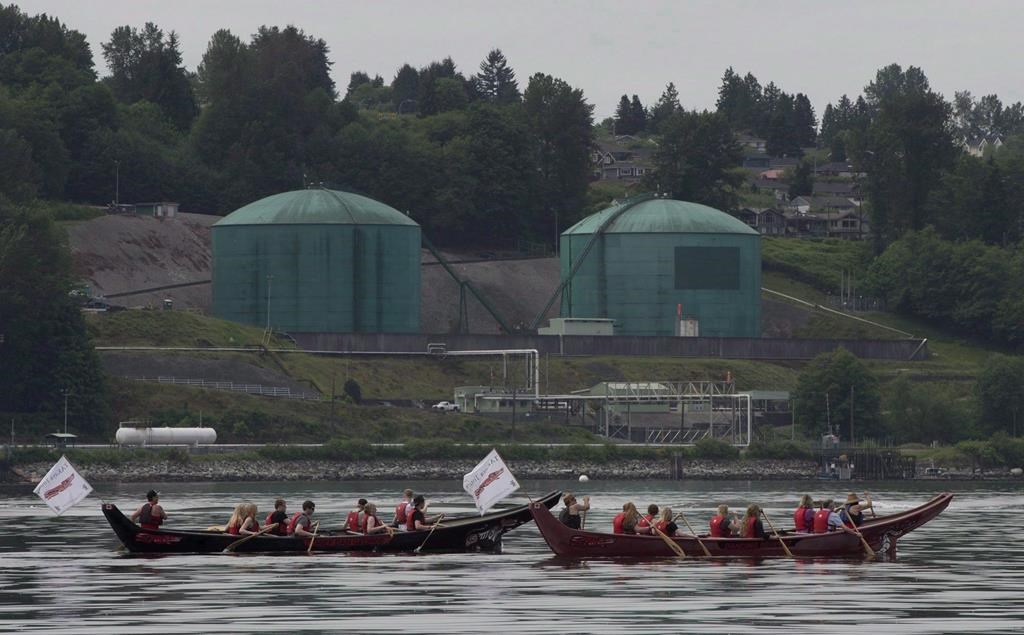Canoeists paddle first nation canoes past the Kinder Morgan facility in Burrard Inlet in North Vancouver, B.C. Thursday, May, 22, 2014.Four British Columbia Indigenous groups are set to argue in the Federal Court of Appeal that the Canadian government failed to consult adequately with them before its latest approval of the Trans Mountain pipeline expansion. THE CANADIAN PRESS/Jonathan Hayward.
